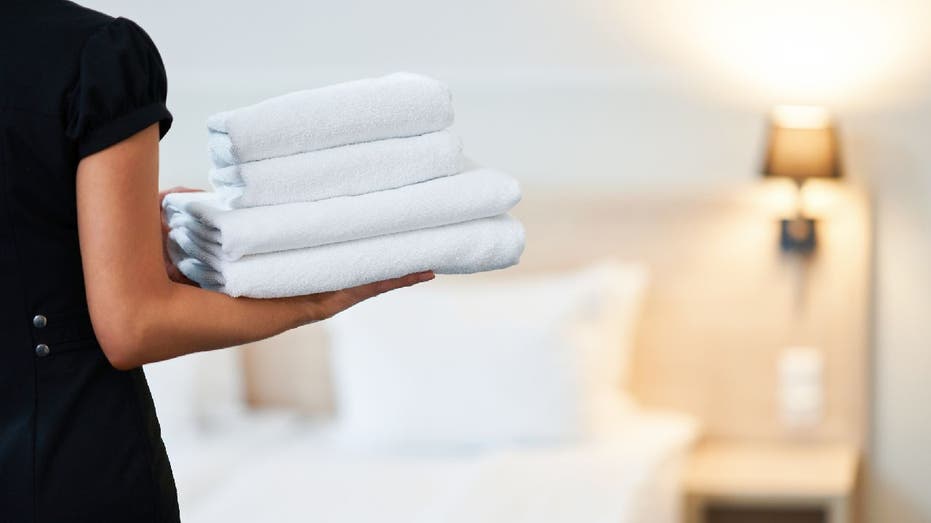 Woman brings clean towels to room