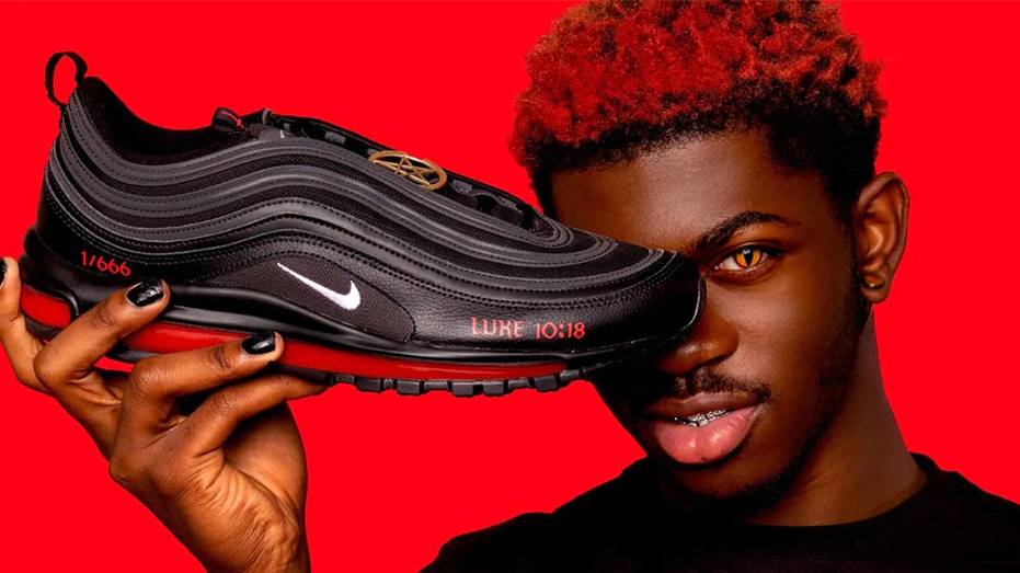 Lil Nas X holds up Satan Shoes from MSCHF